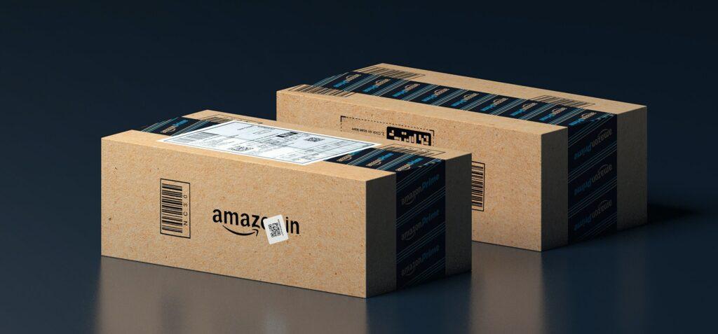 Zwei kleine Amazon-Pakete sind mit Strichcode und Lieferetikett versehen und liegen zum Versand bereit nebeneinander 
