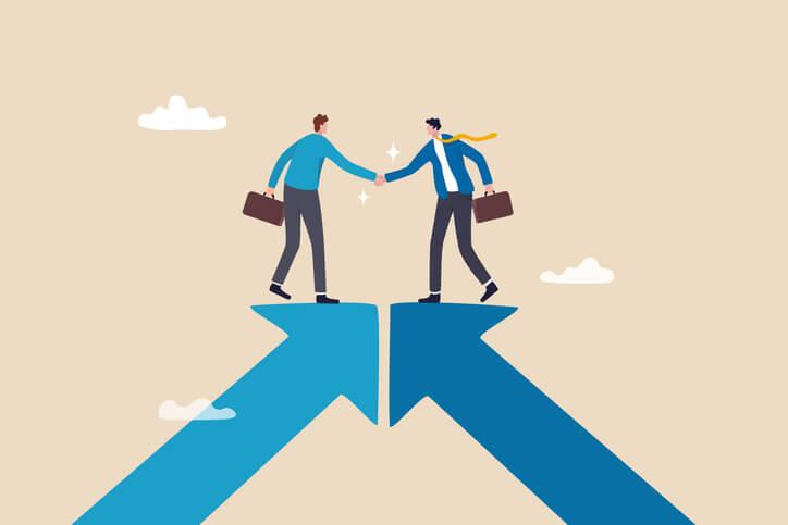 An illustration of two businessmen standing on top of converging arrows and shaking hands, indicating building relationships in your SaaS partner programs.