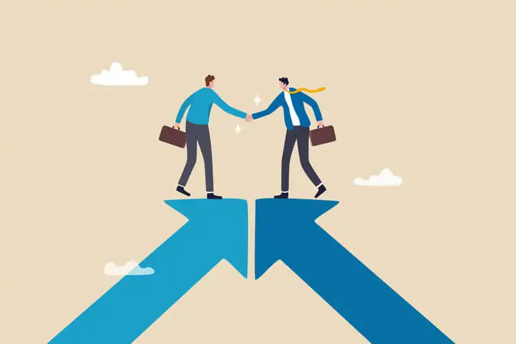 An illustration of two businessmen standing on top of converging arrows and shaking hands, indicating the development of a business vision as part of business transformation.