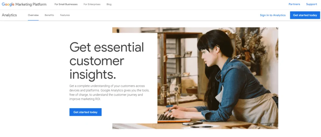Screenshot of Google Analytics main page showing the top menu, a woman working on her laptop, and text about how the tool can provide essential customer insights.